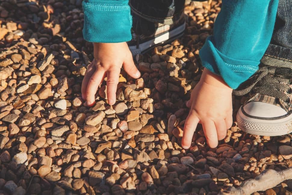 Child playing with gravel — proprioceptive engagement