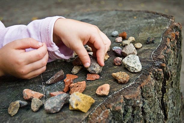 Child exploring stones — tactile sensory play